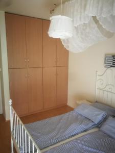 - une chambre avec un lit et un placard dans l'établissement Promenade Apartman, à Balatonlelle