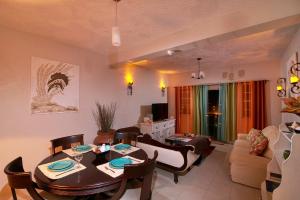 a living room with a table and chairs and a couch at Atlantic Breeze Apartments, Canouan Island in Canouan