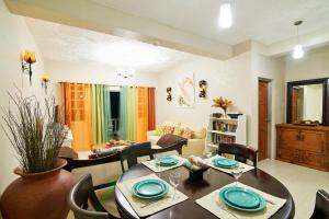 uma sala de estar com mesa e cadeiras em Atlantic Breeze Apartments, Canouan Island em Canouan