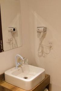 W łazience znajduje się biała umywalka i lustro. w obiekcie Hotel Paddock w São Paulo