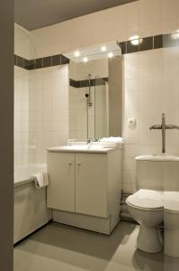 La salle de bains est pourvue de toilettes, d'un lavabo et d'une baignoire. dans l'établissement Residhotel Les Hauts d'Andilly, à Andilly