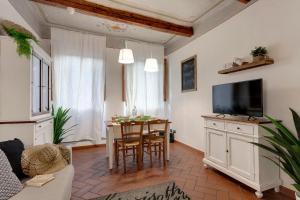 - un salon avec une table et une télévision dans l'établissement Mamo Florence - Ghibellina Apartment, à Florence