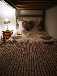 1 cama con edredón marrón y blanco y lámpara en Le petit Chamois en Saint-Gervais-les-Bains