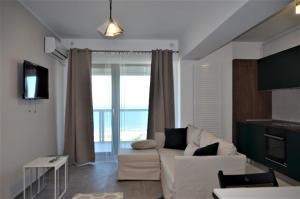 a living room with a white couch and a large window at Mamaia Beach LuxyMar 1 Apartment in Mamaia