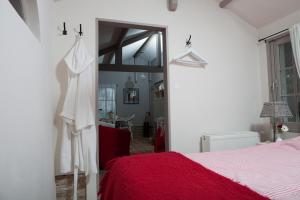 a bedroom with a red bed and a mirror at In d'Ouwe Vlaamse Schuur in Ossendrecht