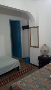 a room with two beds and a blue door at Bed & breakfast Villa Carmo in Salvador