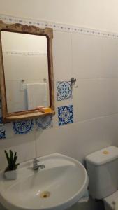 a bathroom with a sink and a mirror and a toilet at Bed & breakfast Villa Carmo in Salvador