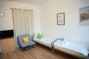 Zimmer mit 2 Betten, einem Stuhl und einem TV in der Unterkunft Contactless Check-In Room4You Währing in Wien