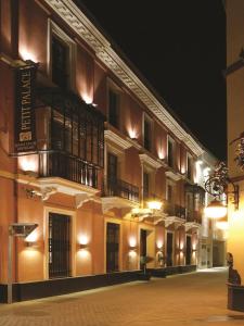 ein Gebäude mit Balkon seitlich in der Nacht in der Unterkunft Petit Palace Marques Santa Ana in Sevilla