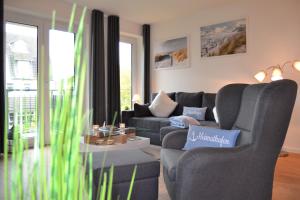 un salon avec un canapé et une chaise dans l'établissement Appartement Ankerplatz 2 SZ 2 Balkone by Unsere Urlaubszeit, à Kellenhusen