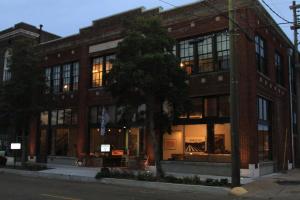 een bakstenen gebouw met een boom ervoor bij Travelers Hotel in Clarksdale