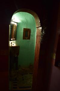 an archway with a green wall with a light at Dar Bejmate - Chez Hassan in Tacheddirt