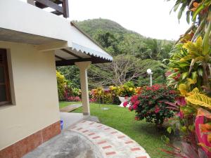 uma casa com um jardim com flores e um passadiço em La Mirabelle em Le Vauclin