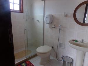 a bathroom with a shower and a toilet and a sink at Kazaya Pousada in Araruama