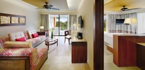 ein Wohnzimmer mit einem Sofa und einem Tisch in einem Zimmer in der Unterkunft Barceló Maya Beach - All Inclusive in Xpu Ha