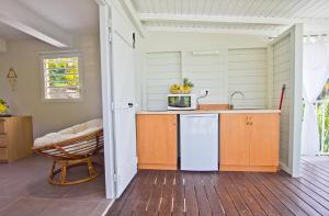 a kitchen with a refrigerator and a table at O Coeur de Deshaies Appartements Grande Anse et Amandiers in Deshaies