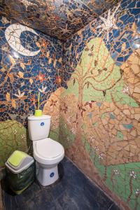 a toilet in a bathroom with graffiti on the walls at Aji Verde Hostel San Pedro in San Pedro de Atacama