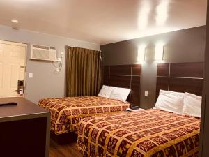 Кровать или кровати в номере Red Carpet Inn - Norristown