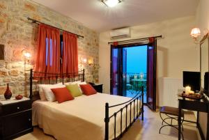 ein Schlafzimmer mit einem großen Bett und einem Balkon in der Unterkunft Byzantinon Hotel in Leonidi
