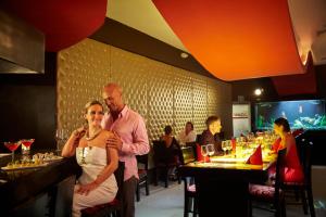 a man and a woman standing in a restaurant at Desire Riviera Maya Resort All Inclusive - Couples Only in Puerto Morelos