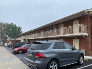 un coche aparcado en un aparcamiento frente a un edificio en Red Carpet Inn - Norristown, en Norristown