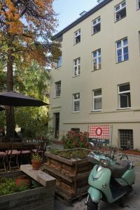 a scooter parked in front of a building at Madflats Hotel-Apartments S-Bahn Friedenau in Berlin