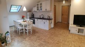 a kitchen and dining room with a table and a television at Lavender Hill in Messinghausen