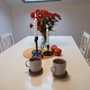 zwei Kerzen und zwei Tassen Kaffee auf dem Tisch in der Unterkunft Lavender Hill in Messinghausen