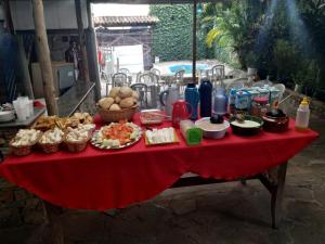 une table avec un tissu de table rouge et de la nourriture dans l'établissement Pousada Acayaca, à Diamantina