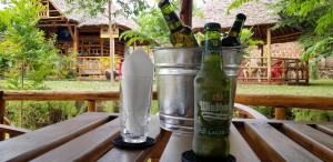 MsarangaにあるAivlys Lodge Kilimanjaroの木製テーブルに座ったビール2本