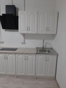 a kitchen with white cabinets and a sink at Квартира новая in Odesa