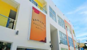 ボラカイにあるKamusta Boutique Hotelの建物脇のオレンジ色の看板