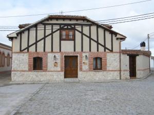 une vieille maison en pierre avec un noir et blanc dans l'établissement Senda Del Alba, à Fresneda de Cuéllar