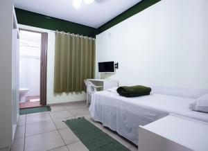 um quarto com uma cama, uma televisão e uma janela em Hospedaria Lumo Domo Praça da Árvore em São Paulo