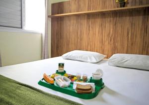 a tray of food sitting on top of a bed at Hospedaria Lumo Domo Praça da Árvore in São Paulo
