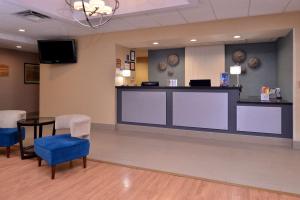 a waiting area in a hospital with a counter and chairs at Best Western Plus University Inn in Olean