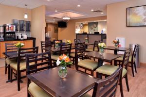 a restaurant with tables and chairs with flowers on them at Best Western Plus University Inn in Olean