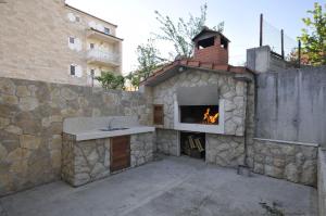 eine Außenküche mit einem Kamin in einem Gebäude in der Unterkunft Apartments Ivica - parking in Kaštela