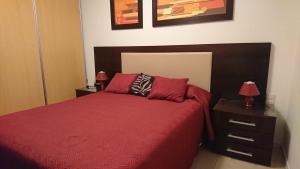 1 dormitorio con 1 cama roja y 2 almohadas rojas en Ro, en Punta del Este