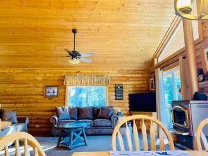 a living room with a couch and a ceiling fan at Adventure Awaits 3King Bed,2Bath Log Cabin in heart of Duck Creek Village! in Duck Creek Village