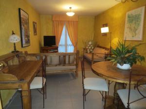 a living room with tables and chairs and a television at Hostal Casa Juan in Castejón de Sos