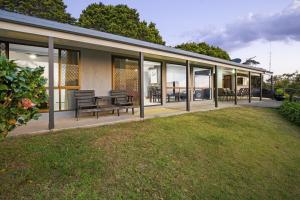 a house with windows and benches on a lawn at The Bird House in Mount Tamborine