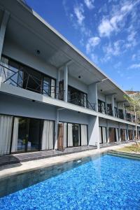 a building with a swimming pool in front of it at The Grey Boutique Inn in Legian