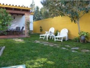 a group of white chairs sitting in a yard at Casa Jazmín in Zahora