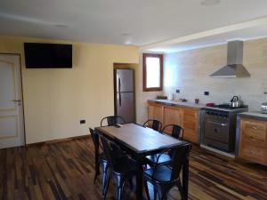 y cocina con mesa, sillas y fogones. en Chacra Arana cabaña de campo, en Villa Regina 26 fotos más