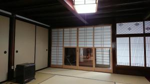 a room with white walls and a room with a window at 百年町家 佐野邸 in Nanao