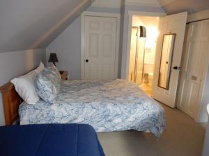 a bedroom with a bed with a blue and white comforter at 2br Empire Avenue WALK to Lifts and Main St - No Car Required! in Park City +23 photos