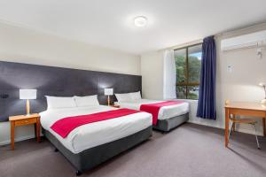a hotel room with two beds and a window at Knox International Hotel and Apartments in Wantirna