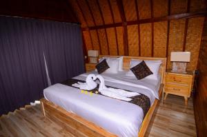 zwei Schwäne auf einem Bett in einem Zimmer in der Unterkunft Batur Panorama in Kintamani