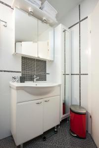 een witte badkamer met een wastafel en een rode kruk bij Apartment Pico Bello in Vodice
